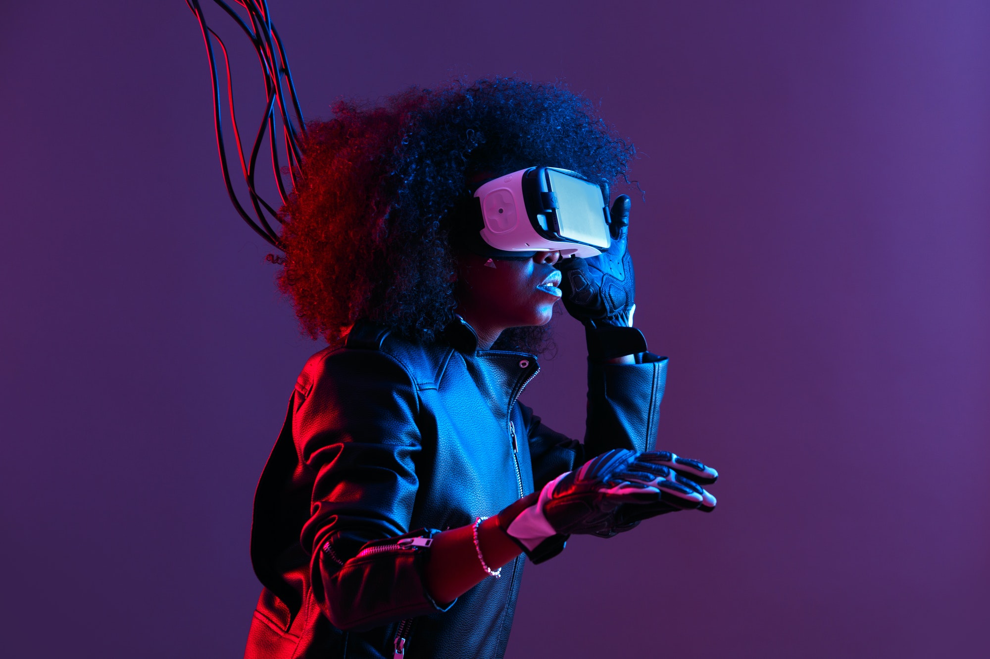 mod-curly-dark-haired-girl-dressed-in-black-leather-jacket-and-gloves-uses-the-virtual-reality.jpg